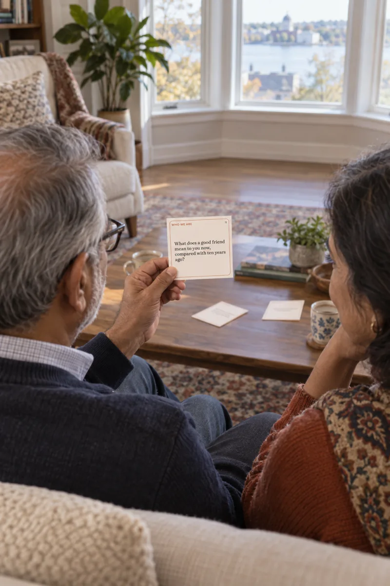 An older couple on a sofa, he holds conversation card 11 and answers first while she listens